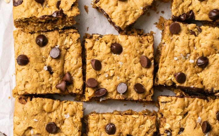 Healthy peanut butter oatmeal cookie bars cut into squres on parchment paper.