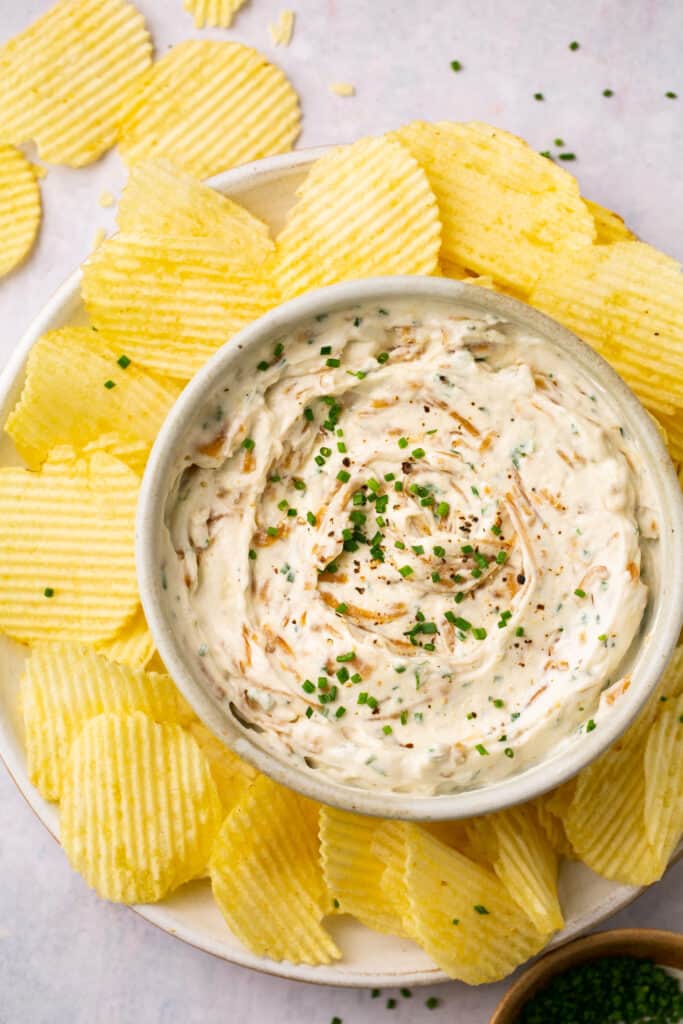 Healthy french onoin dip topped with chives and garnished with crinkle cut chips.