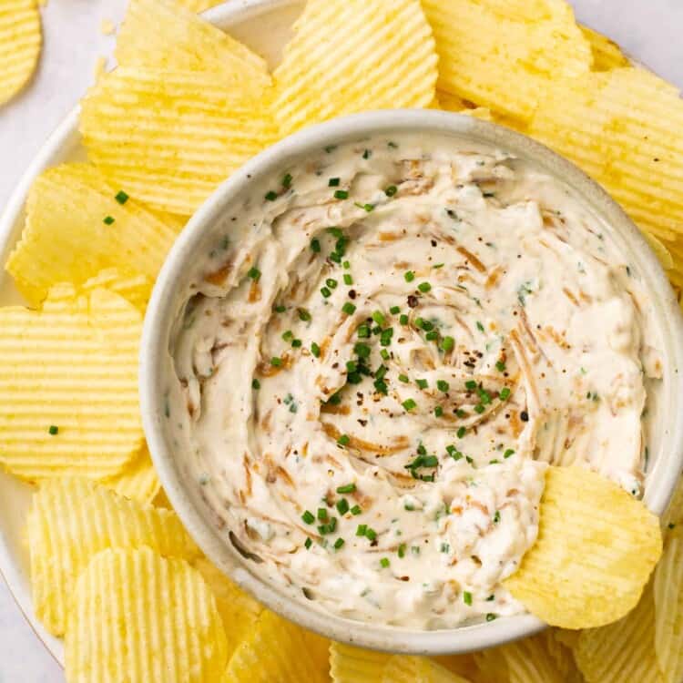 Healthy french onoin dip topped with chives and garnished with crinkle cut chips.