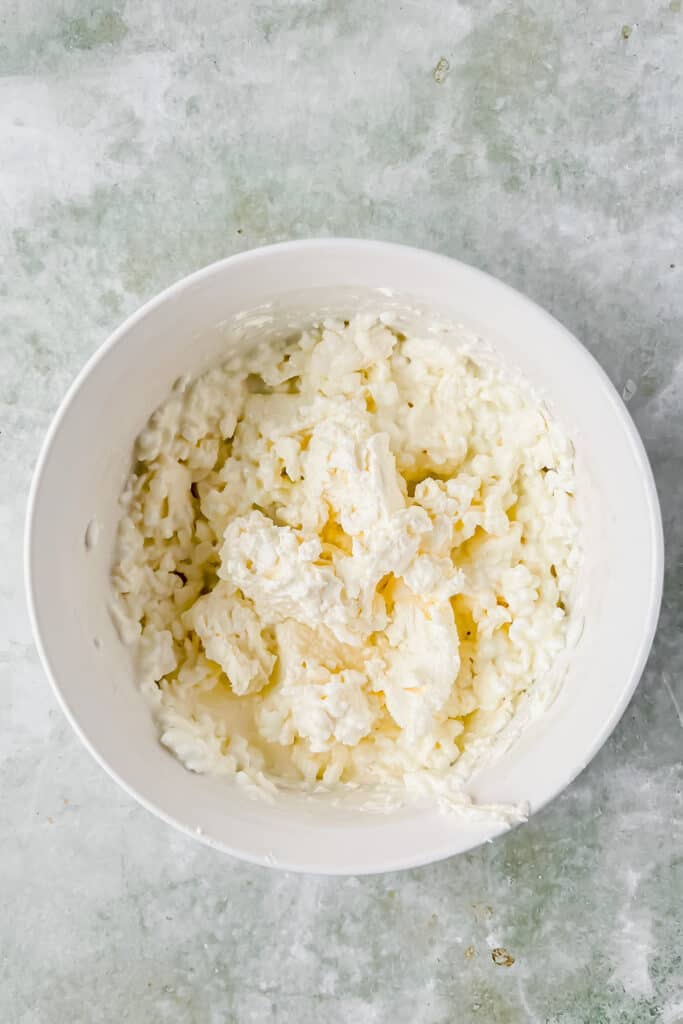 Cream cheese, cottage cheese, and seasonings in a mixing bowl.