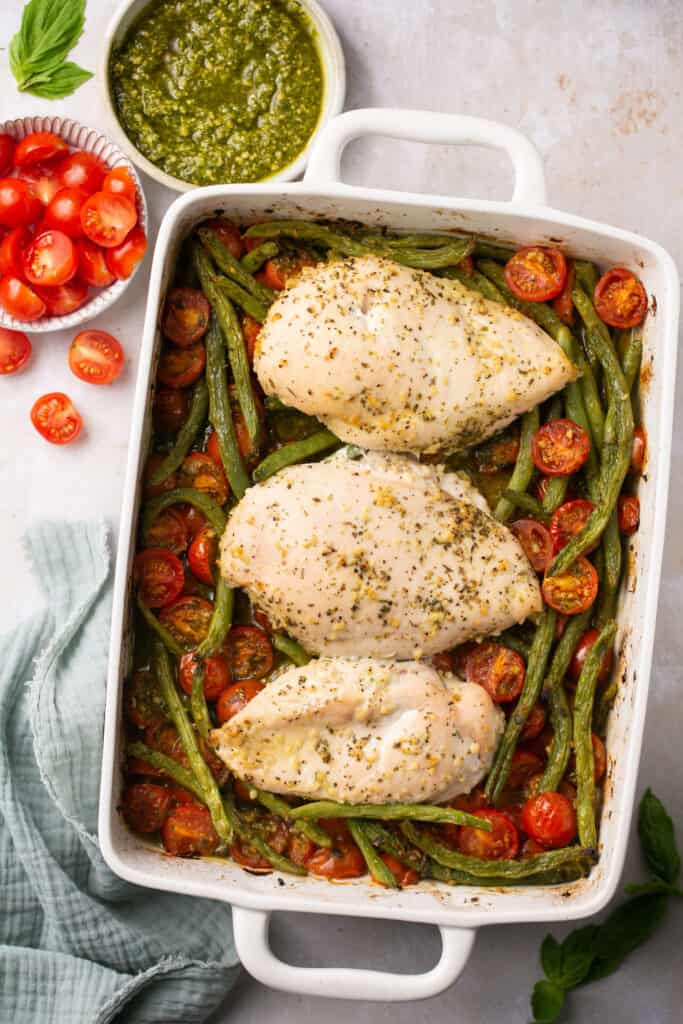 Baked pesto chicken in a baking dish after being baked.