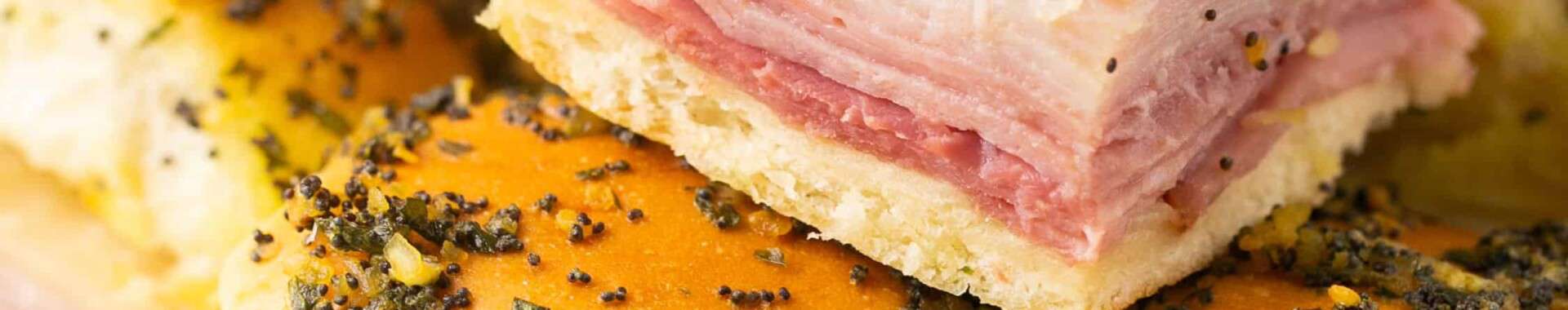 Healthy ham and cheese sliders stacked on a plate.