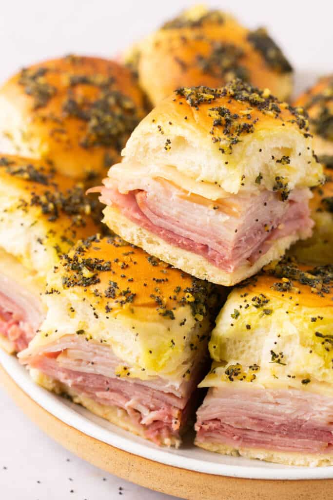 Healthy ham and cheese sliders stacked on a plate.