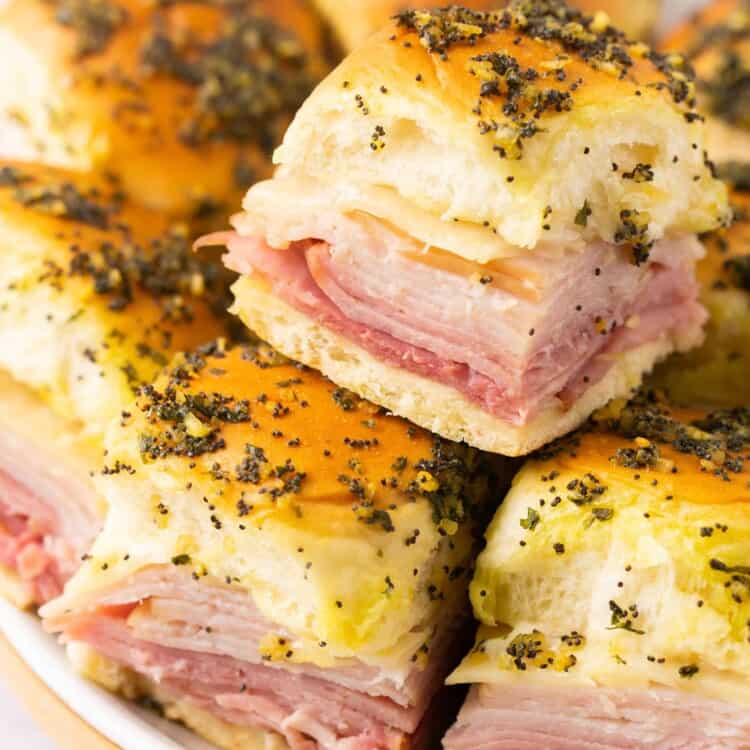 Healthy ham and cheese sliders stacked on a plate.