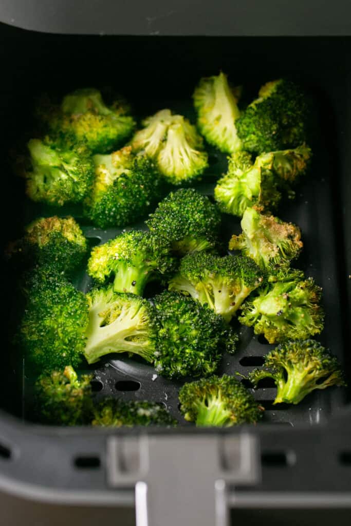 Cooked broccoli in an air fryer basket