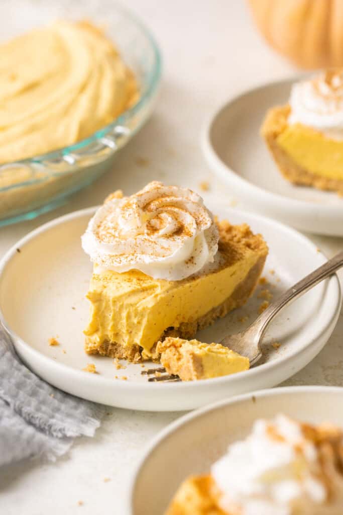 Slices of no bake pumpkin dessert pie on small plates with forks.