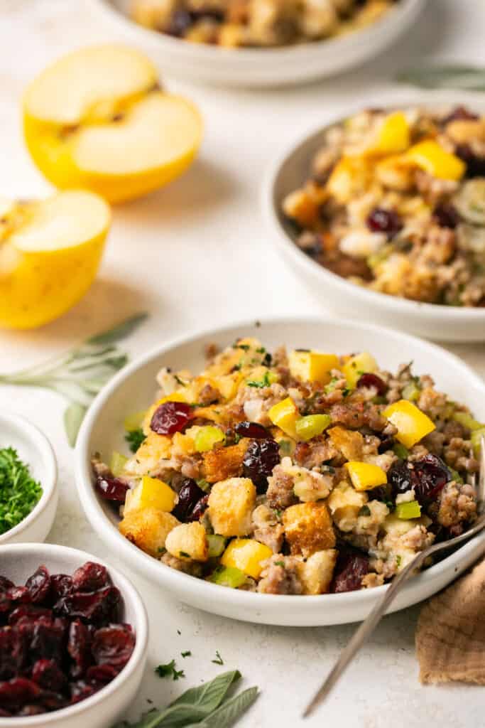 Sausage apple cranberry stuffing served in a small bowl with a fork