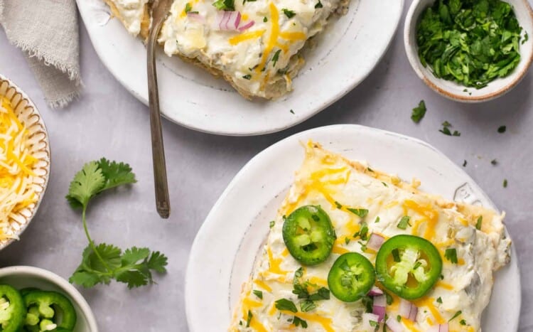 Servings of Creamy Green Chili Chicken Enchilada Stack on small plates.