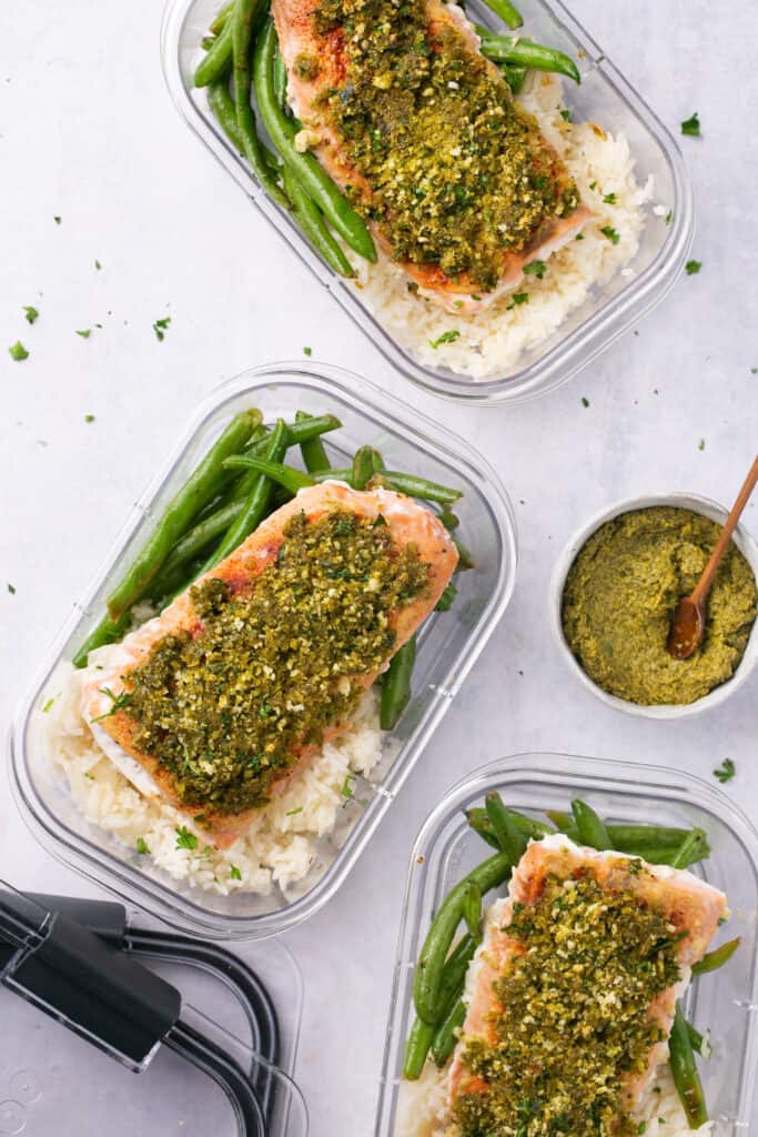 Pesto salmon with rice and green beans in meal prep containers
