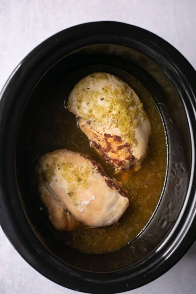 Salsa verde chicken in the crock pot after being cooked.