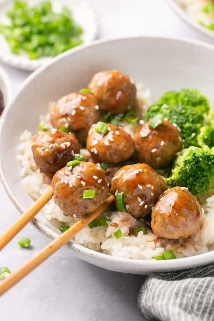 3 ingredient meatballs served in a bowl with broccoli and rice, topped with green onion and sesame seeds