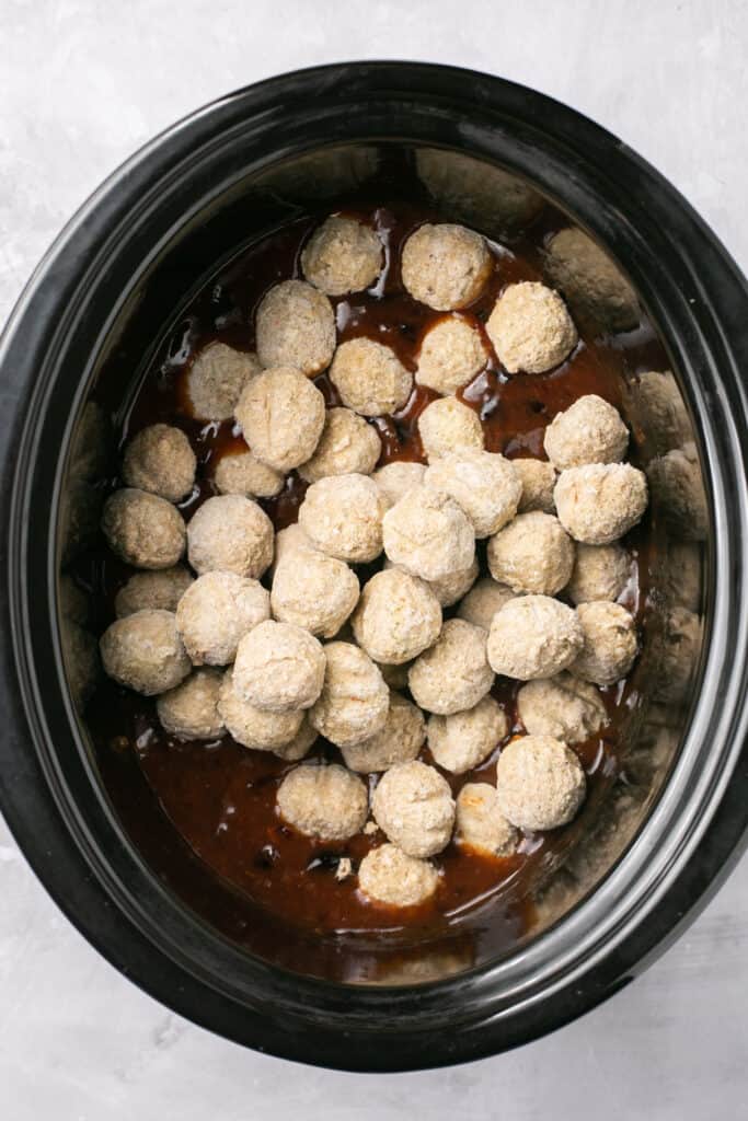 Frozen meatballs added to the sauce ingredients in a slow cooker.