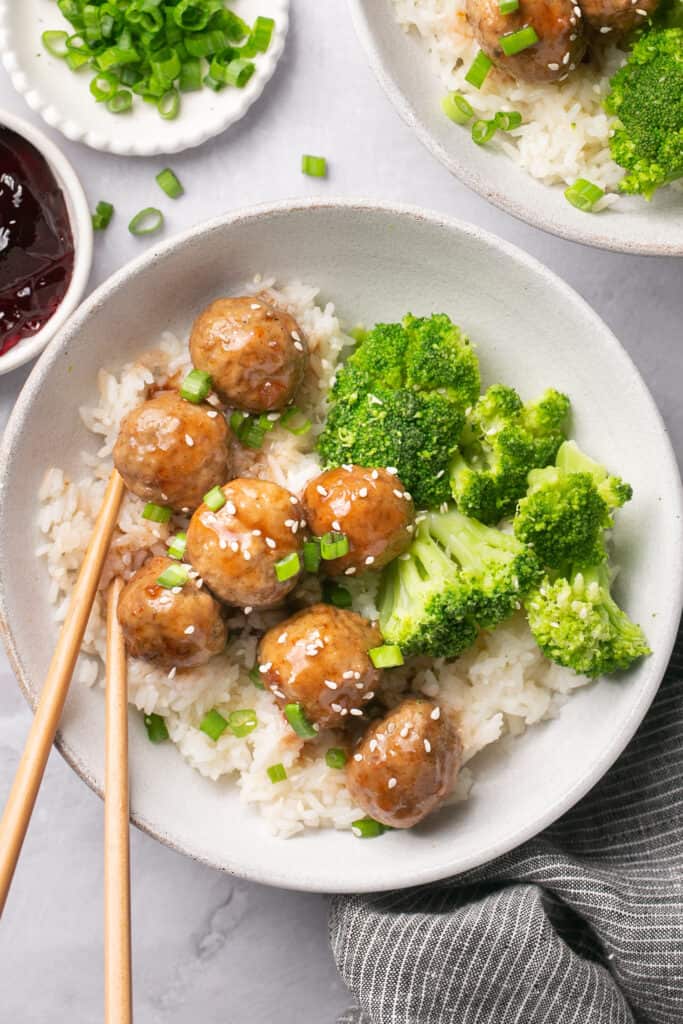 3 ingredient meatballs served in a bowl with broccoli and rice, topped with green onion and sesame seeds
