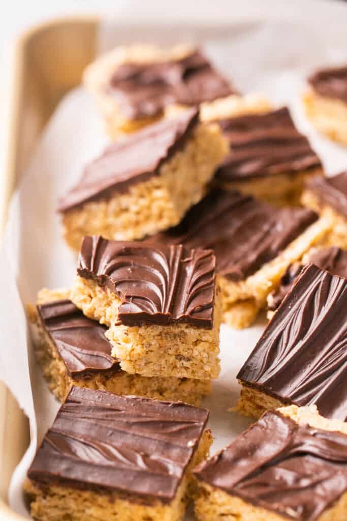 Healthy scotcheroos  cut into bars on a baking sheet with parchment paper.