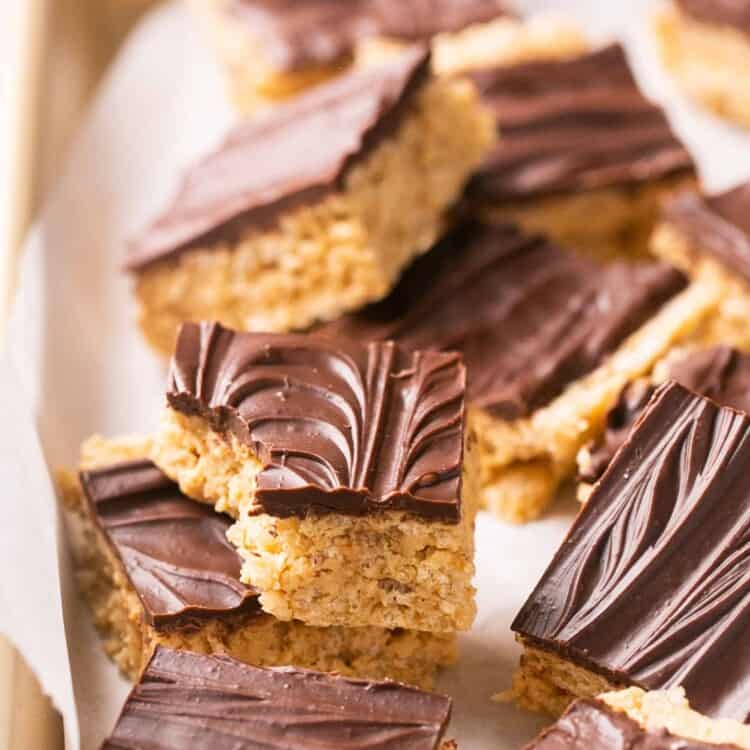 Healthy scotcheroos cut into bars on a baking sheet with parchment paper.