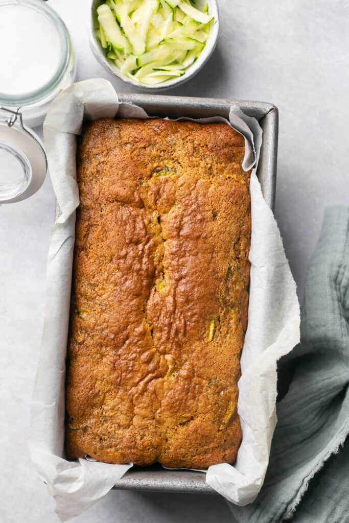 Healthy gingerbread zucchini bread in a loaf pan with parchment paper.