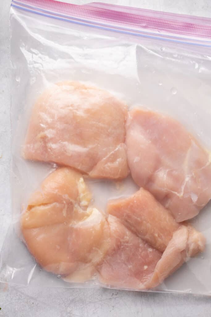 Raw chicken breasts in a zip lock bag.