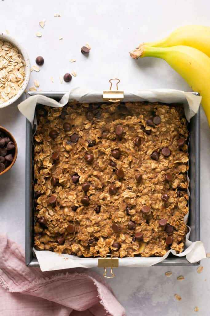 Peanut butter banana oatmeal bars  in a baking pan with parchment paper after being baked.