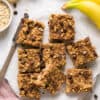 Peanut butter banana oatmeal bars cut into squares on parchment paper.
