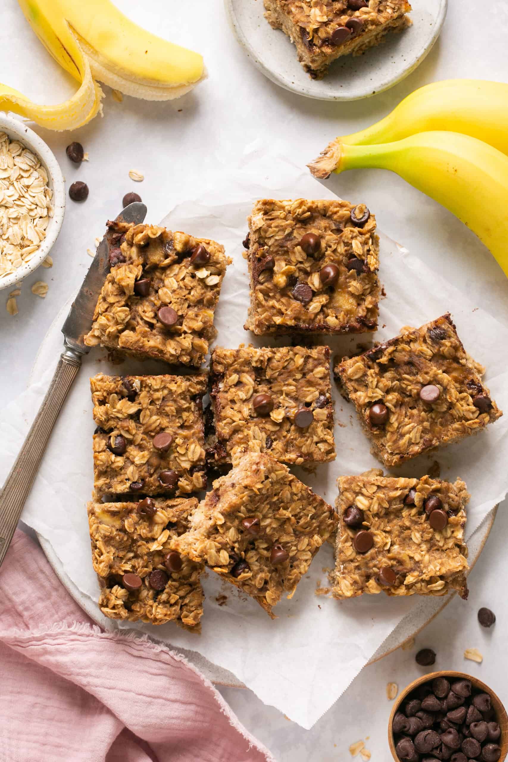 Peanut butter banana oatmeal bars cut into squares on parchment paper.