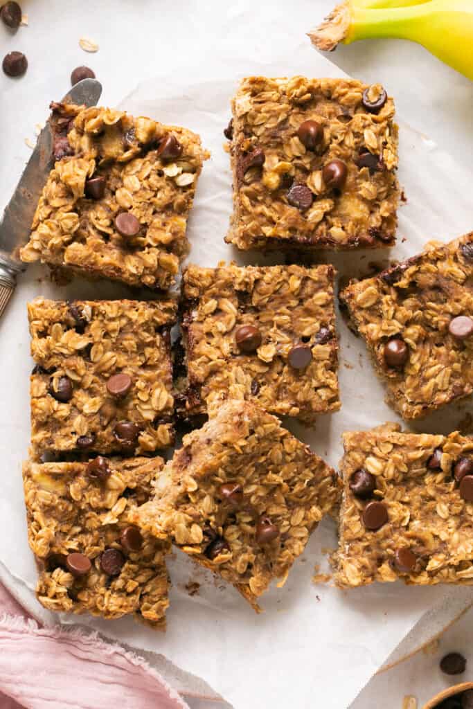 Peanut butter banana oatmeal bars cut into squares on parchment paper
