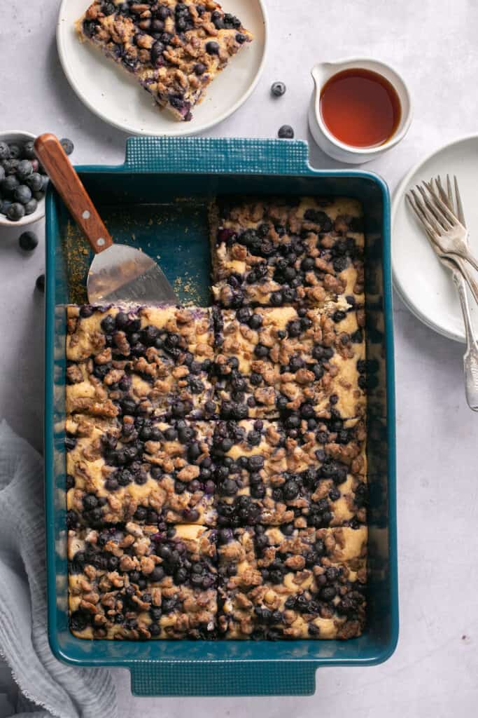 Sausage pancake breakfast bake with blueberries in a baking dish being served.
