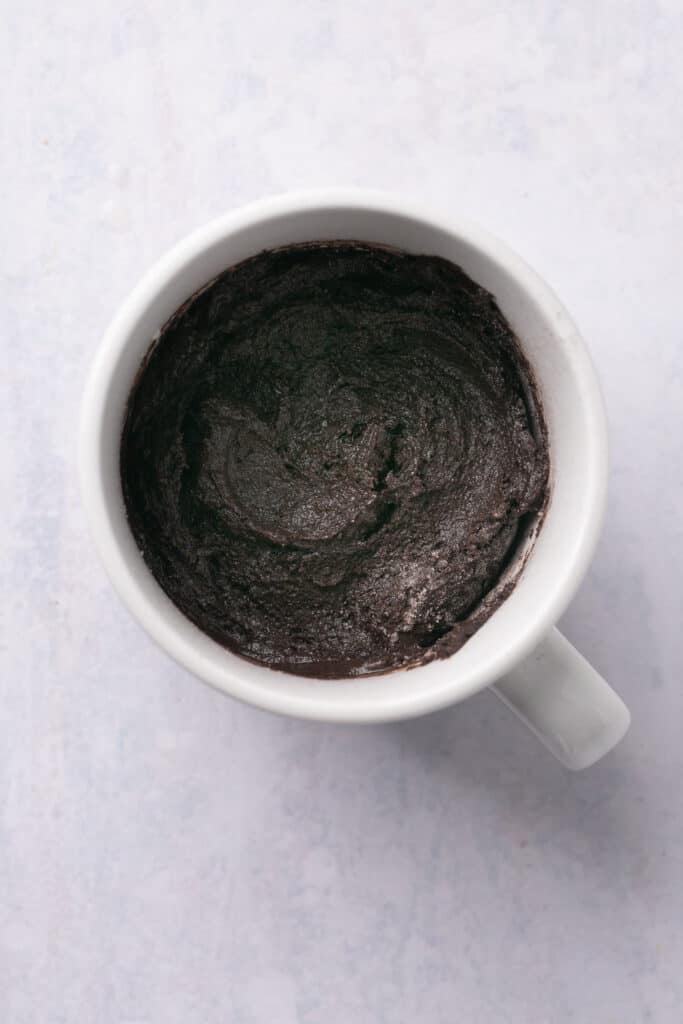 Chocolate protein lava cake batter in a mug.