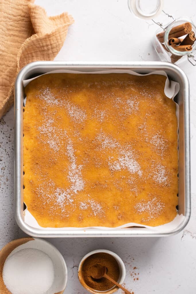Cinnamon sugar protein cake bar batter in a square baking pan.