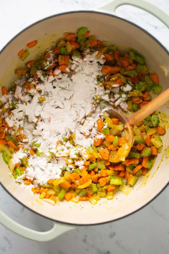 Flour sprinkled over the chopped veggies and spices in a dutch oven.