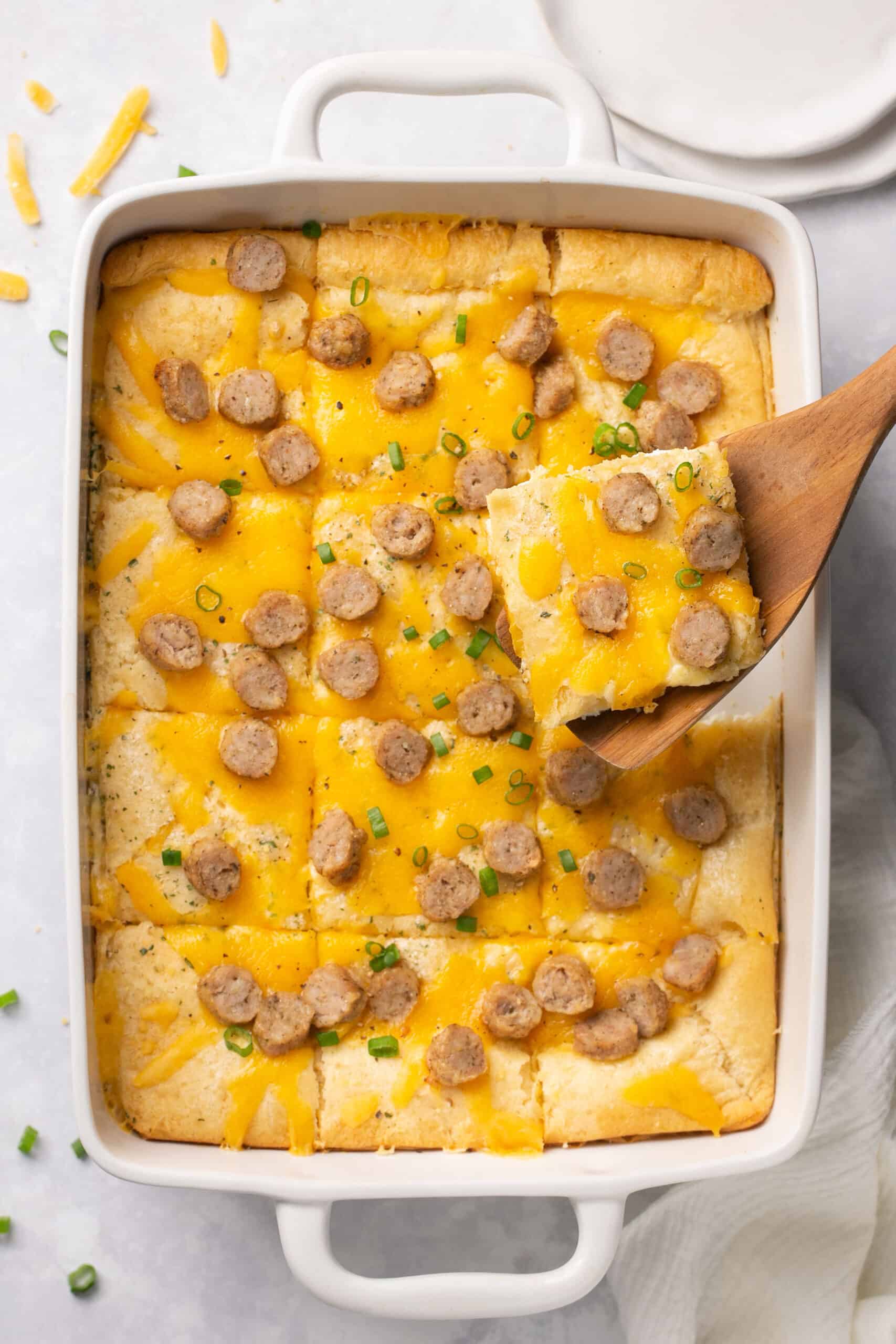 Cheddar Chicken Sausage Crescent Roll Breakfast Pizza in a baking dish cut into servings.