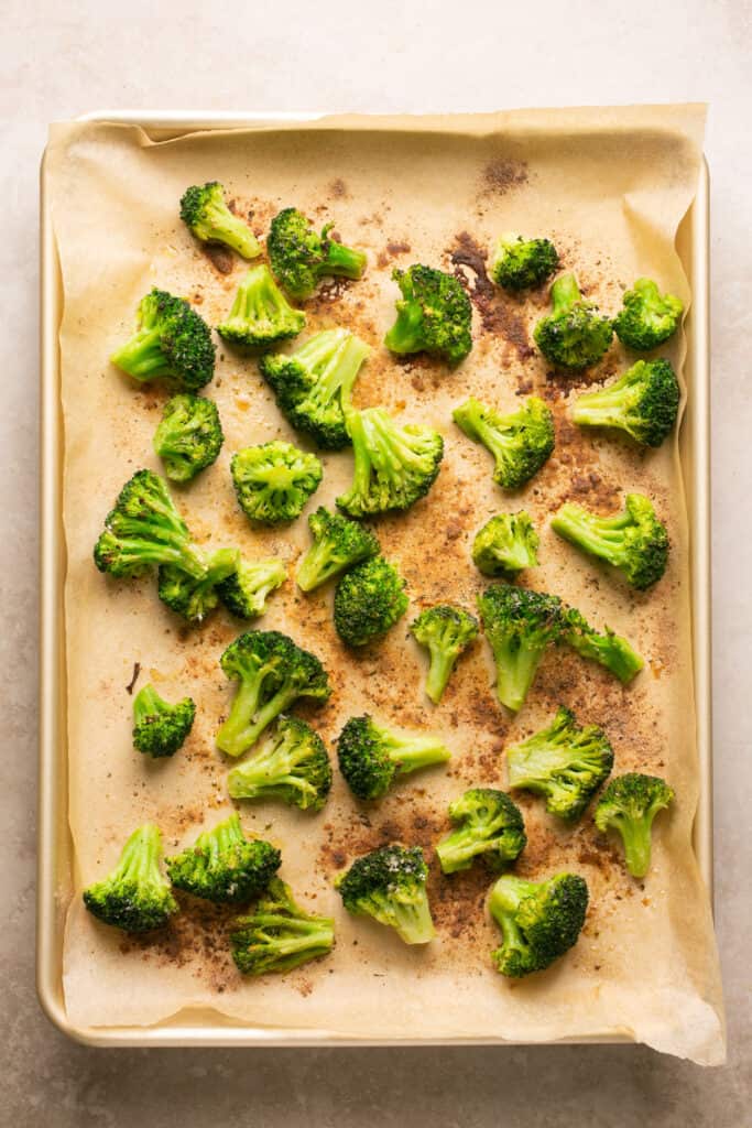 Crispy broccolli on a baking sheet with parchment paper.