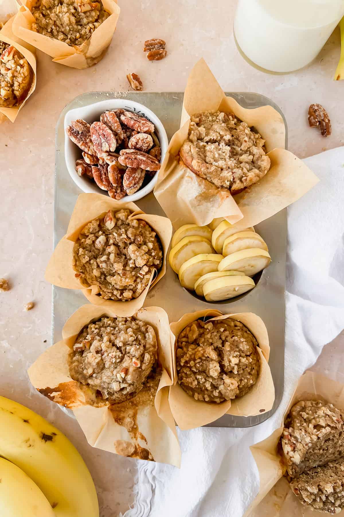 Banana nut protein muffins with pecan crumble on a tray.
