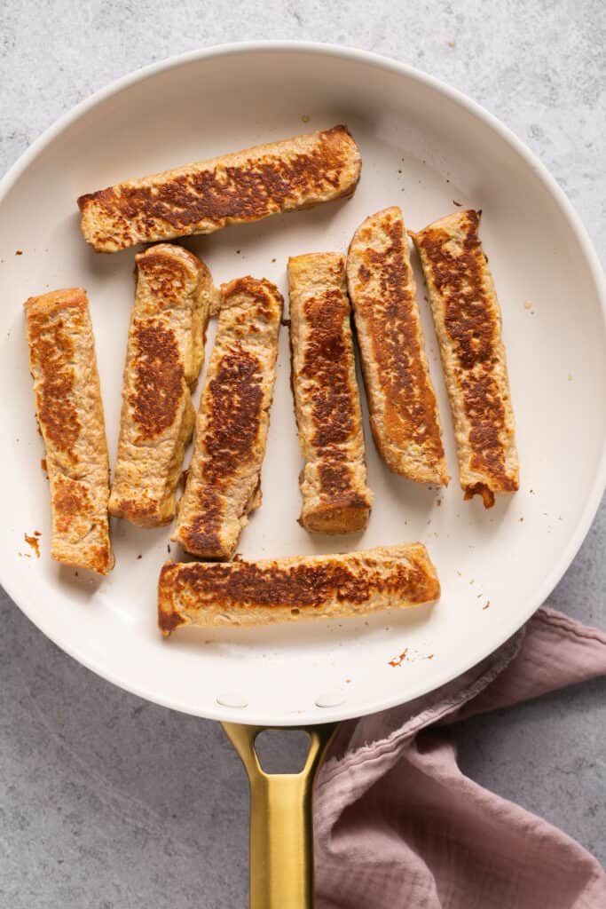 Protein french toast sticks in a skillet after being cooked.