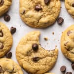 Small batch chocolate chip cookies one with a bite take out of it on parchment paper.