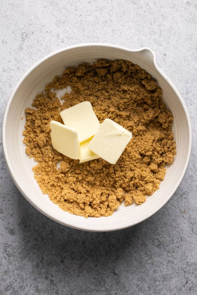 Butter and sugar in a bowl before being mixed together.