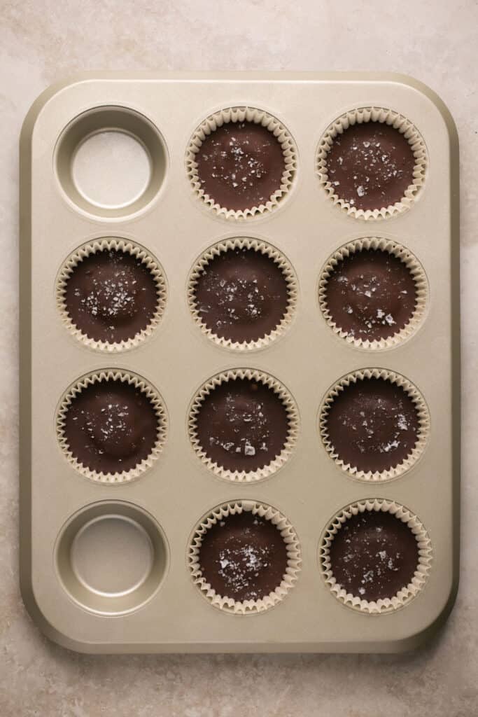 Flake salt added on top of the cookie dough cups in the mini muffin pan.