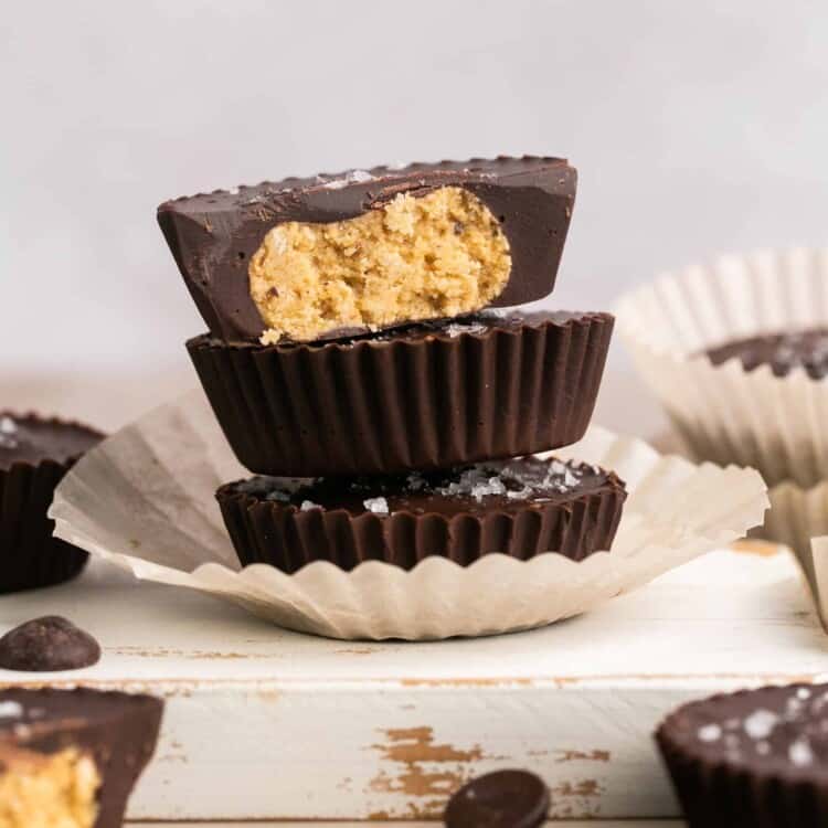 Healthy chocolate cookie dough cups stacked on top of each other on a small plate.