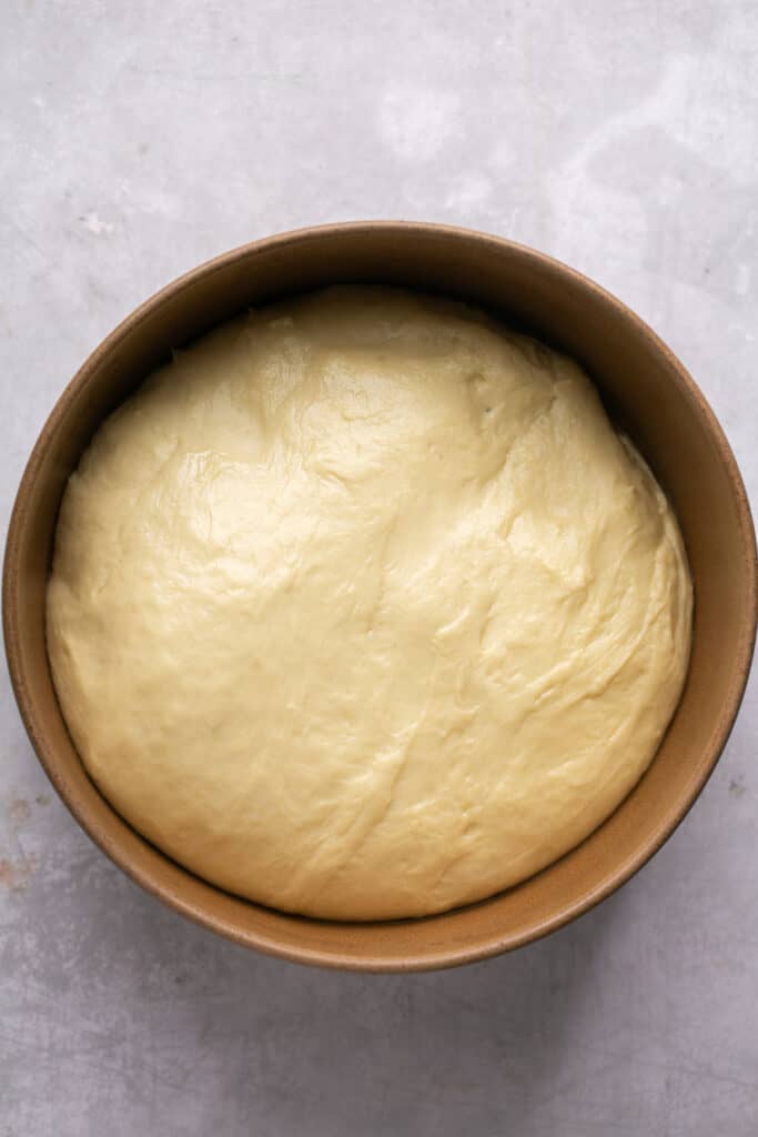 Risen dough for honey butter yeast rolls in bowl. 