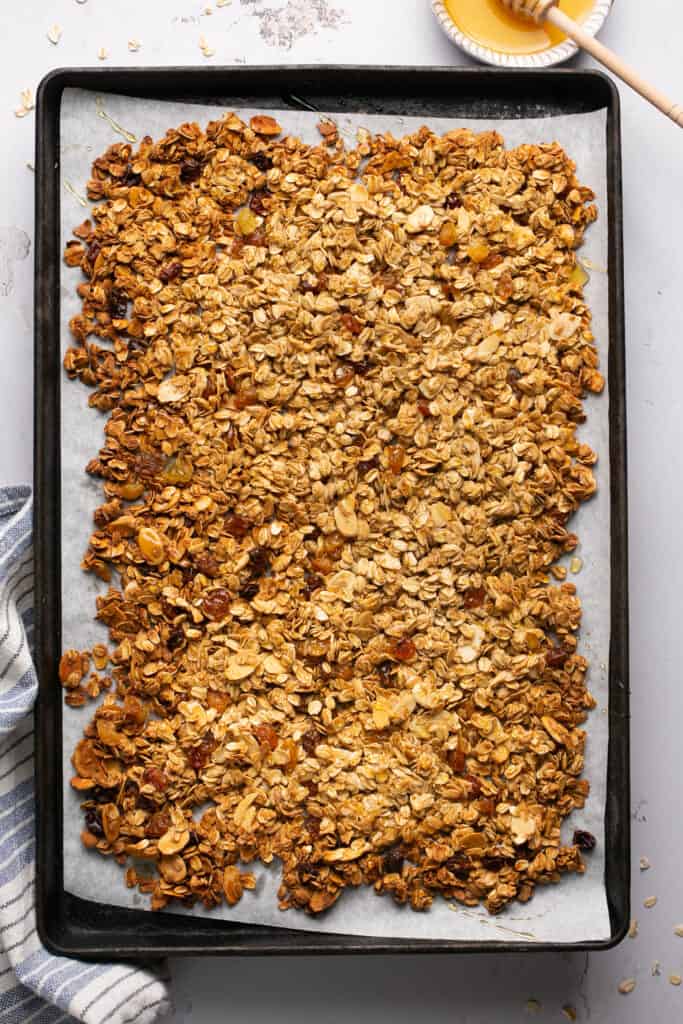 Honey almond granola on a baking sheet with parchment paper