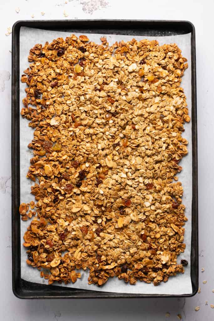 Honey Almond Granola recipe on a baking sheet with parchment paper after being baked.