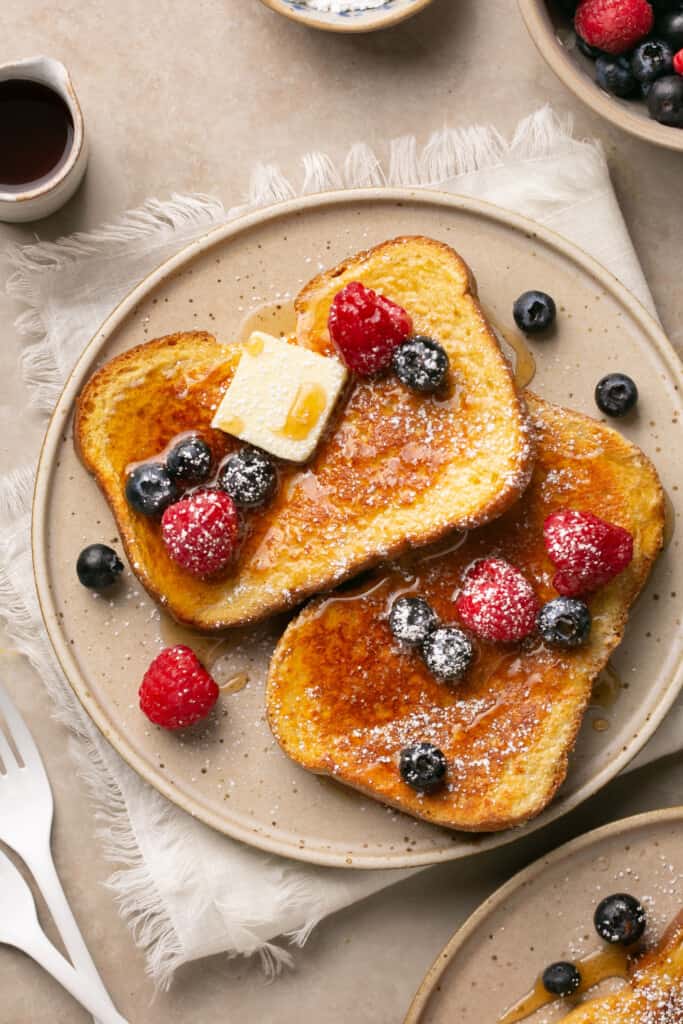 Protein french toast topped with butter and berries served on a plate.