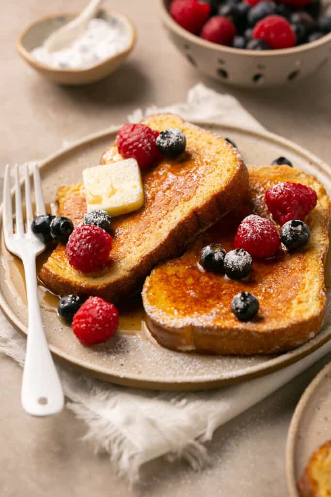 Protein french toast on a plate topped with berries and butter