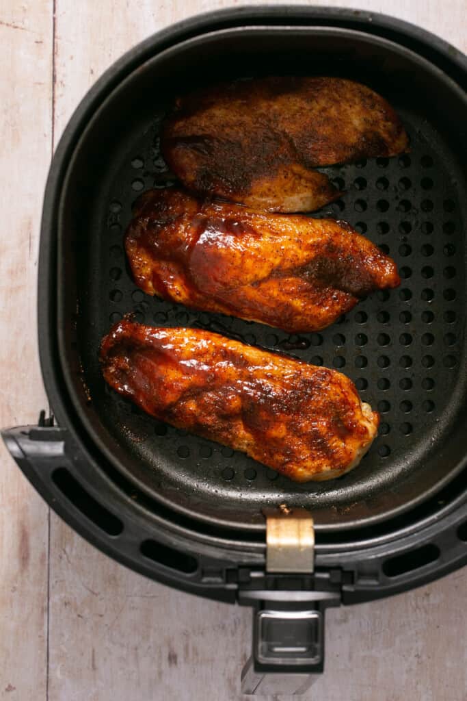 Air fryer bbq chicken (healthy, juicy 20 minutes!) in an air fryer basket after being cooked.