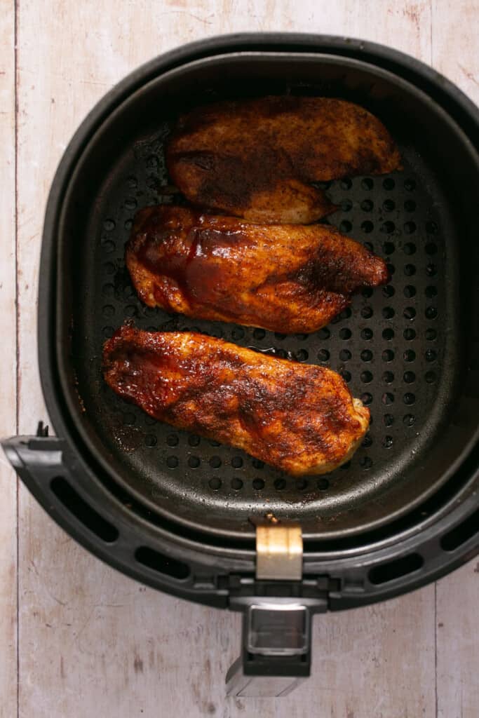 Air fryer bbq chicken (healthy, juicy, 20 minutes!) in an air fryer basket.