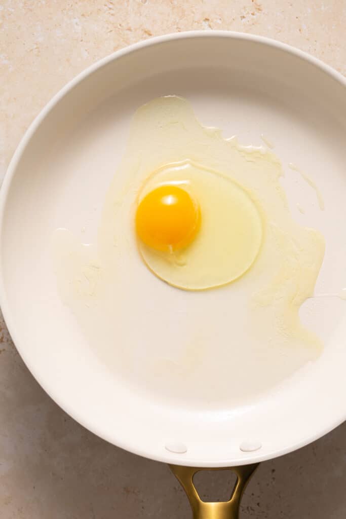 A raw egg in a skillet.