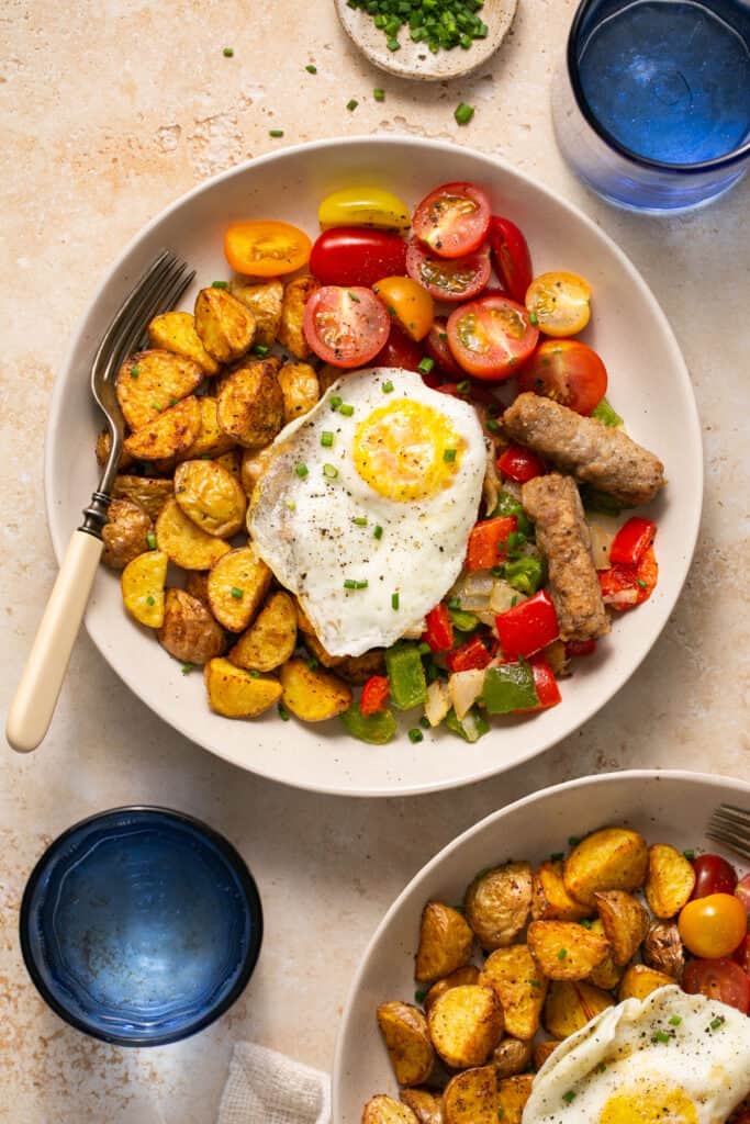 Healthy breakfast bowls with eggs and potatoes in bowls with forks.