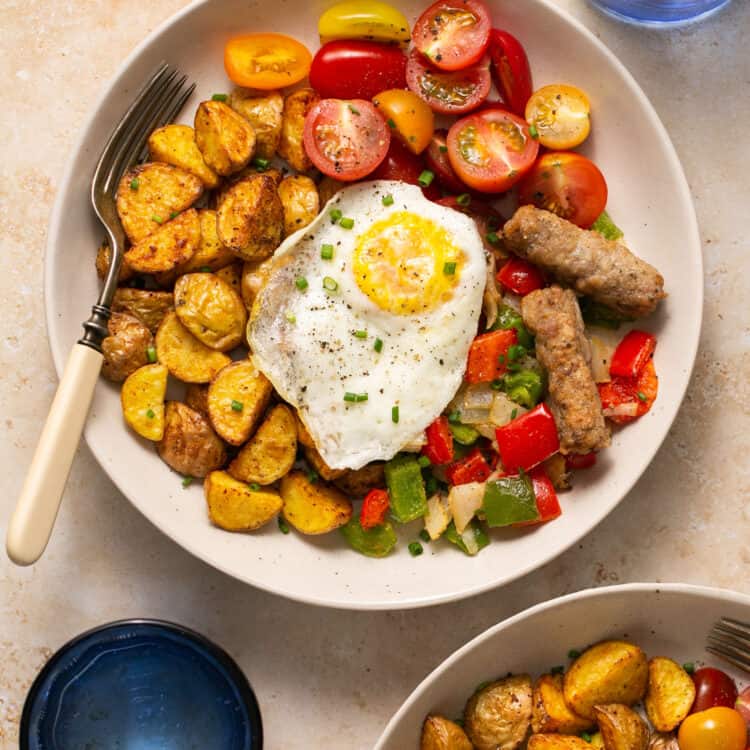 Healthy breakfast bowls with eggs and potatoes in bowls with forks.
