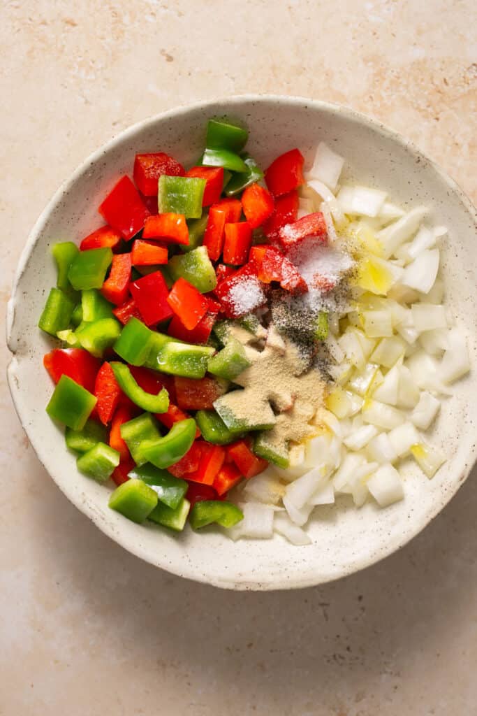 Chopped peppers and onions in a bowl.