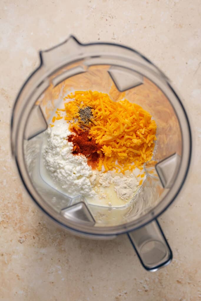 Ingredients for the cheese sauce in a blender before being blended.