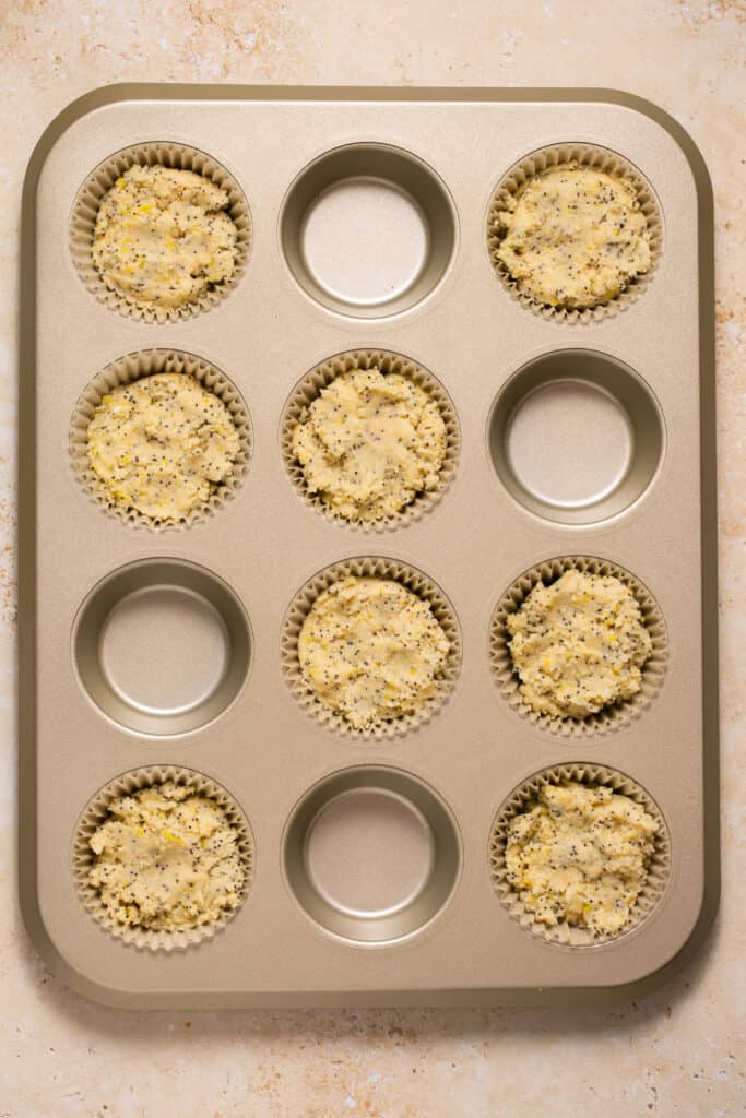 Batter for low carb lemon poppy seed muffins in a muffin tin.